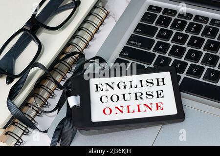 Testo online del corso di inglese scritto su etichetta con nome nero posta su un notebook o un notebook. Concetto di apprendimento online. Foto Stock