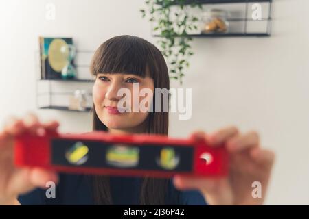 Fidato architetto caucasico donna con un livello di spirito in primo piano. Foto di alta qualità Foto Stock