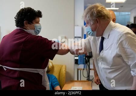 Il primo ministro Boris Johnson urta i gomiti come saluto con un membro del team infermieristico durante una visita al New Queen Elizabeth II Hospital, Welwyn Garden City, Hertfordshire. Data foto: Mercoledì 6 aprile 2022. Foto Stock