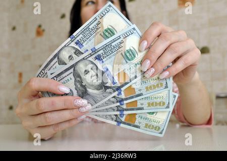La donna russa conta gli ultimi dollari rimasti in contanti in 100 banconote in primo piano. Crisi finanziaria. Foto Stock