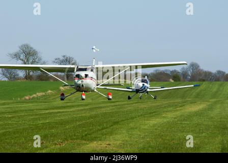 Cessna 172 e British Aerospace Bulldog aerei che tassano per iniziare la gara aerea a Great Oakley, Regno Unito, con un aereo che ha decollato e svolta curva Foto Stock