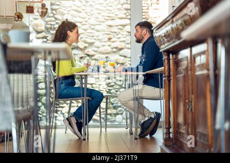 Giovani coppie di turisti che parlano e che hanno fatto colazione in un hotel Foto Stock