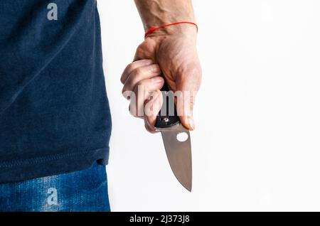 L'uomo ha le mani nei guanti che tengono il coltello Foto Stock