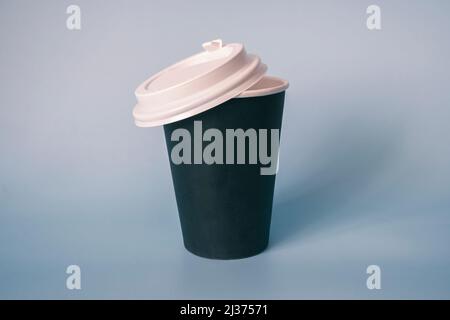 Tazza di caffè di carta nera su sfondo blu. Spazio vuoto per testo e design. Modulo per il nome del caffè o dell'azienda o del bar Foto Stock