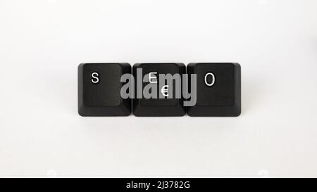 Testo SEO creato con tasti della tastiera isolati su sfondo bianco, SEO bianco su tastiera nera, vista dall'alto Foto Stock