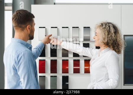 Il concessionario automatico e il cliente selezionano il colore della vettura in base ai campioni sulla tavolozza Foto Stock