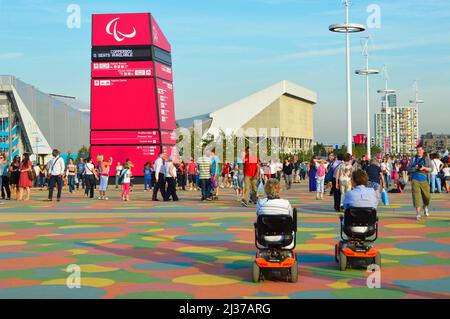 Londra 2012 Olimpiadi visitatori disabili e spettatori a piedi si muovono tra le sedi sportive nel parco olimpico al Paralympic Games Stratford Newham Inghilterra UK Foto Stock