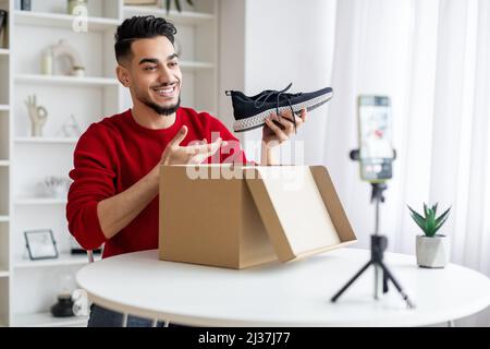Fashion Blog. Young Arab Male Influencer registrazione di contenuti video a casa Foto Stock