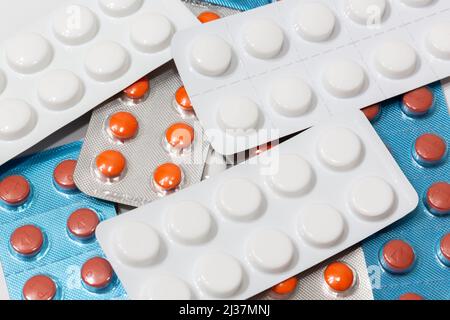 Pillole disposte casualmente di pillole a fuoco selettivo. Pillole di colori diversi. Concetto di salute. Foto Stock