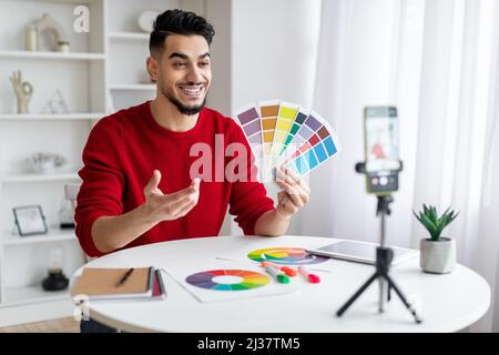 Concetto di tutoring. Arab Male Graphic Designer che dimostra i campioni di colore alla fotocamera del telefono Foto Stock