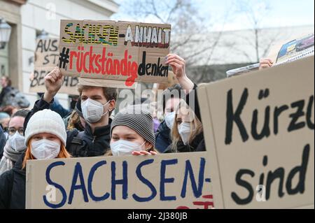 06 aprile 2022, Sassonia-Anhalt, Halle (Saale): Gli studenti hanno scritto "Think Sassonia-Anhalt backward" su un cartello. Erano giunti ad un raduno contro il pacchetto di austerità previsto all’Università di Halle. In questo modo, protestano contro la cancellazione di fondi da parte del governo statale per il personale in quasi tutte le aree dell'università. Il motivo del raduno è il successivo incontro del Senato della Martin Luther University Halle-Wittenberg. Foto: Heiko Rebsch/dpa Foto Stock