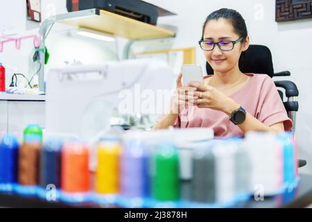 Ricamo, artigianato, hobby, PMI, famiglia, Ritratto di designer asiatici femminili stanno facendo progettando modelli utilizzando automatico Foto Stock