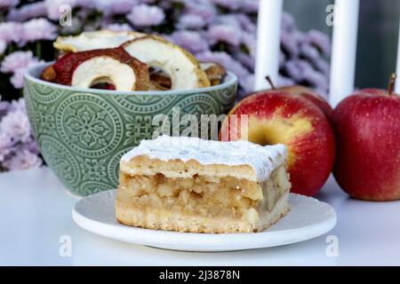 Porzione di torta di mele e mele fresche sullo sfondo. Dessert da festa Foto Stock