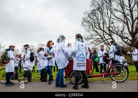 L'Aia, Paesi Bassi. 06th Apr 2022. Un gruppo di scienziati ha visto parlare tra loro durante la dimostrazione. Come parte dell'organizzazione climatica Extinction Rebellion, gli scienziati marciano attraverso l'Aia durante la prima marcia degli scienziati sul clima nei Paesi Bassi. Indossando camici da laboratorio, la marcia si fermò davanti al Ministero delle Finanze, al Ministero dell'Economia e del clima e agli edifici del Ministero degli Affari Esteri. (Foto di Ana Fernandez/SOPA Images/Sipa USA) Credit: Sipa USA/Alamy Live News Foto Stock