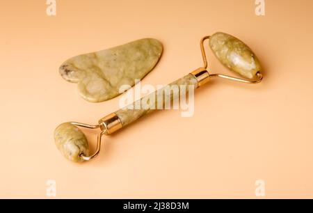 Strumenti di massaggio Gua Sha. Raschietto e rullo Jade. Bellezza facciale e concetto di salute della pelle. Cura del corpo a casa o in salone. Sollevamento, tonificazione e trattamento anti-età. Foto di alta qualità Foto Stock