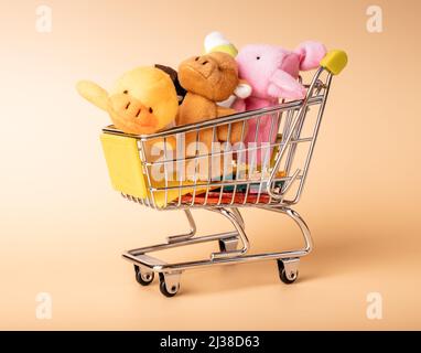 Animali ripieni, peluche giocattoli nel carrello del supermercato. Acquisto di regali, regali per bambini. Foto di alta qualità Foto Stock
