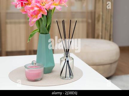 vaso di fiori, diffusore di canne aromatiche e candela Foto Stock