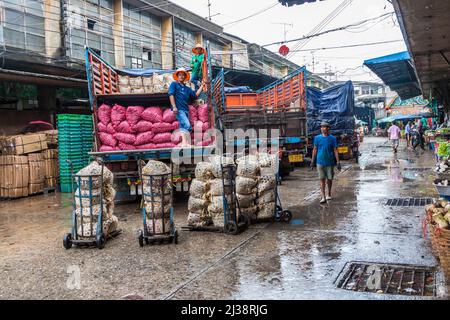 BANGKOK, THAILANDIA - 12 MAGGIO 2009: Le persone caricano i camion sotto la pioggia dopo aver finito il mercato notturno a Pak Klong Talat a Bangkok. Foto Stock