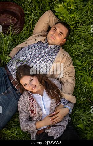 Felice elegante giovane giacente in erba verde Foto Stock