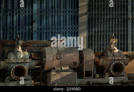 Un vecchio e arrugginito abbandonò le pompe elettriche su un abbandonato. Motori di Old Waters pompe potenti per fabbrica, fuoco selettivo. Foto Stock