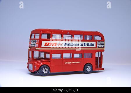Autobus rosso vintage inglese a due piani. Su uno sfondo bianco piano. Foto Stock