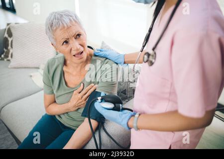 Quelle farfalle arent. Shot di una donna anziana interessata che ha la sua pressione sanguigna leggere a casa. Foto Stock