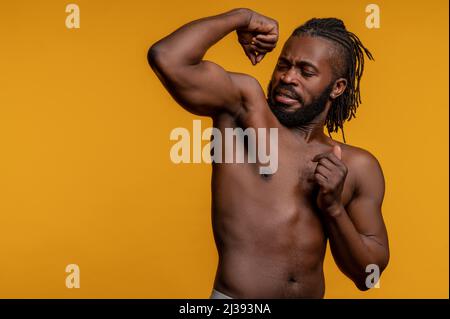 Atleta che getta uno sguardo arrabbiato alla sua ascella sudata Foto Stock