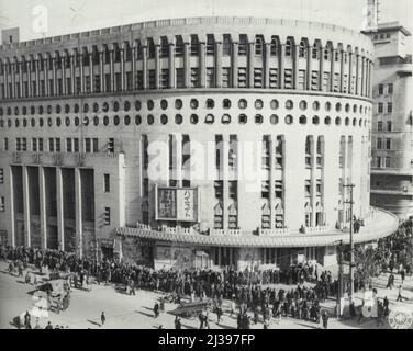 JAPS Crowd Theaters for U.S. Movies -- migliaia di teatri giapponesi di Tokyo, con le stelle dell'intrattenimento, per la prima visione in quattro anni di film americani, molto popolari prima della guerra. Questa vista di uno dei moderni luoghi cinematografici di Tokyo mostra lunghe file di uomini, donne e bambini che aspettano pazientemente di entrare. Febbraio 25, 1946. (Foto di US Army Signal Corps Photo). Foto Stock