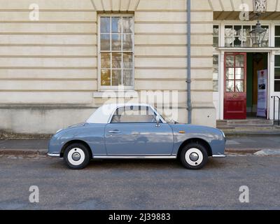 Londra, Greater London, Inghilterra, 02 2022 aprile: Molto carino Nissan Figaro auto convertibile in blu con un tetto bianco. Foto Stock