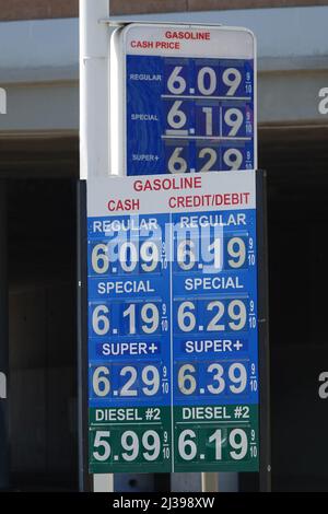 Un cartello della stazione di servizio visualizza i prezzi correnti del carburante a oltre $6 USD per gallone, situato vicino ad una strada negli Stati Uniti durante il giorno. Foto Stock