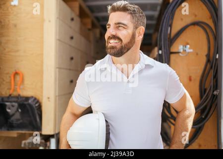 uomo con un elmetto in piedi davanti al camion Foto Stock