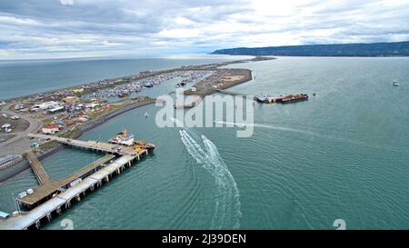 Un colpo ad angolo alto di Homer Spit in Alaska con barche e navi che caricano il carico sotto un cielo nuvoloso Foto Stock