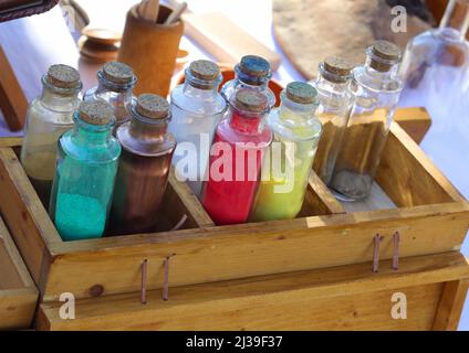 molte bottiglie di vetro con pigmenti liquidi e coloranti utilizzati per colorare i tessuti in epoca medievale Foto Stock