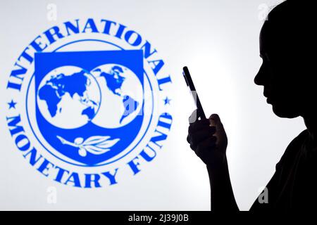Brasile. 06th Apr 2022. In questa foto, la silhouette di una donna contiene uno smartphone con il logo del Fondo monetario Internazionale (FMI) sullo sfondo. (Foto di Rafael Henrique/SOPA Images/Sipa USA) Credit: Sipa USA/Alamy Live News Foto Stock