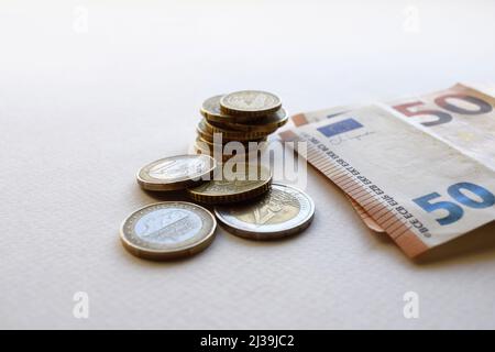 Concetto di banconote e monete in euro su sfondo bianco. Moneta europea. Monete da 1 euro, 2 euro e centesimi. 50 banconote in euro Foto Stock