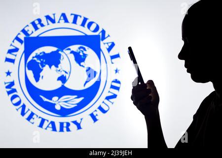 Brasile. 6th Apr 2022. In questa foto, la silhouette di una donna contiene uno smartphone con il logo del Fondo monetario Internazionale (FMI) sullo sfondo. (Credit Image: © Rafael Henrique/SOPA Images via ZUMA Press Wire) Foto Stock