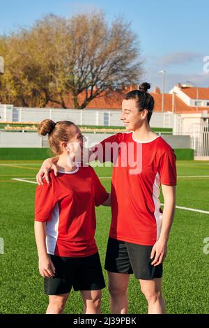 Due giocatori di calcio donne abbracciano e si guardano l'un l'altro Foto Stock