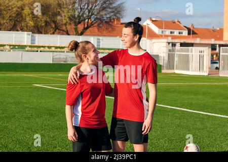 Due giocatori di calcio donne abbracciano e si guardano l'un l'altro Foto Stock