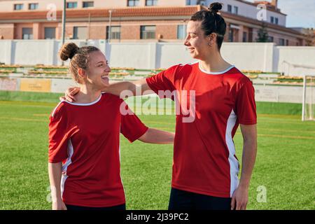 Due giocatori di calcio donne abbracciano e si guardano l'un l'altro Foto Stock