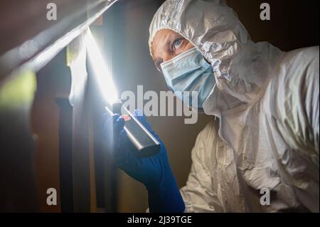 Un esperto ha visto la ricerca di tracce di sangue su una parete. Uno specialista che esamina le tracce di sangue presenta tecniche per l'analisi e la sicurezza delle prove presso la sede della polizia di Voivodship a Gdansk. Foto Stock