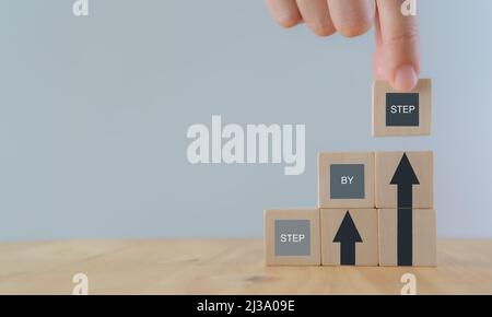 Immagine concettuale della visione aziendale. Lavorare passo dopo passo. La scala del successo. Piano aziendale e del flusso di lavoro. Sostenibilità. Dispone a mano impilando legno Foto Stock