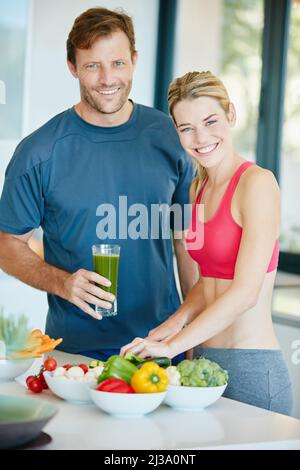 Più sani sei, più ti senti felice. Ritratto di una coppia che prepara un pasto nutriente insieme a casa. Foto Stock