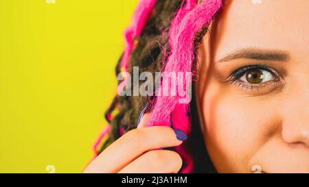 Parte del volto femminile con dreadlock ricci che esprimono emozioni positive. Primo piano. Foto Stock