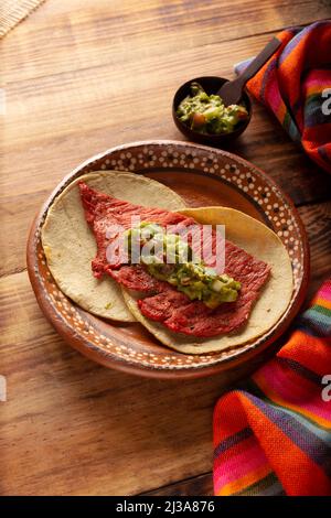 Taco de Cecina enchilada con Guacamole. Carne di maiale o di manzo salata, essiccata al sole, condita con varie spezie e peperoncini, solitamente mangiata in tacos Foto Stock