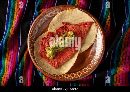 Taco de Cecina enchilada con Guacamole. Carne di maiale o di manzo salata, essiccata al sole, condita con varie spezie e peperoncini, solitamente mangiata in tacos Foto Stock