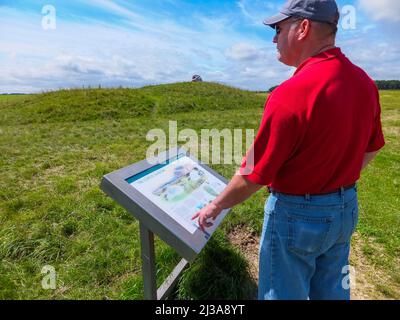 Un uomo guarda fuori sopra i tumuli funerari nelle antiche Barrette di Cursus Neolitico a Stonehenge vicino Amesbury, Salisbury, Inghilterra, Regno Unito. Foto Stock