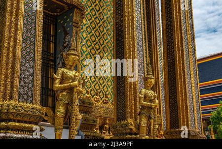 Bangkok, Thailandia - 29 marzo 2022: I demoni d'oro artistico o giganti custode e decorazione delle pareti di Phra Mondop o biblioteca buddista, al tempio Foto Stock
