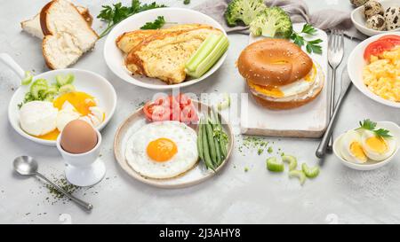 Vari modi di cucinare le uova di pollo su sfondo chiaro. Concetto di cibo per la colazione. Foto Stock