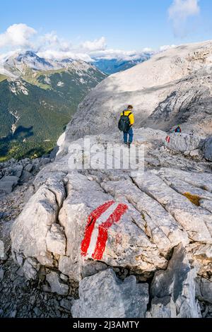 Escursionisti che discendono da Hohe Munde, segnando sul sentiero, dietro cresta rocciosa della catena montuosa di Wetterstein, Mieminger Kette, Tirolo, Austria Foto Stock