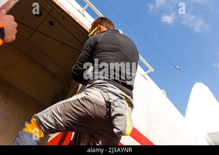 Un vecchio aeroplano classico. Un biplano militare si erge nella neve sugli sci in inverno contro il cielo - preparandosi a volare. Aereo retrò. Aria invernale Foto Stock